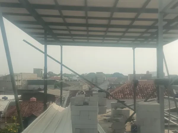 Kanopi baja dengan penutup spandek terpasang di rooftop rumah